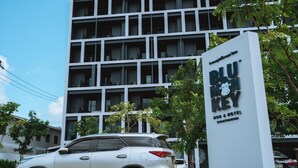 Un edificio de varios pisos con un letrero que dice "Blu Monkey Key Bus & Hotel".