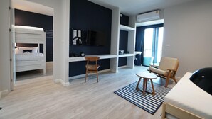Una habitación de hotel moderna con cama, escritorio, silla y televisor.