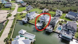 A residential area with houses, a body of water, and a red circle highlighting a specific house.