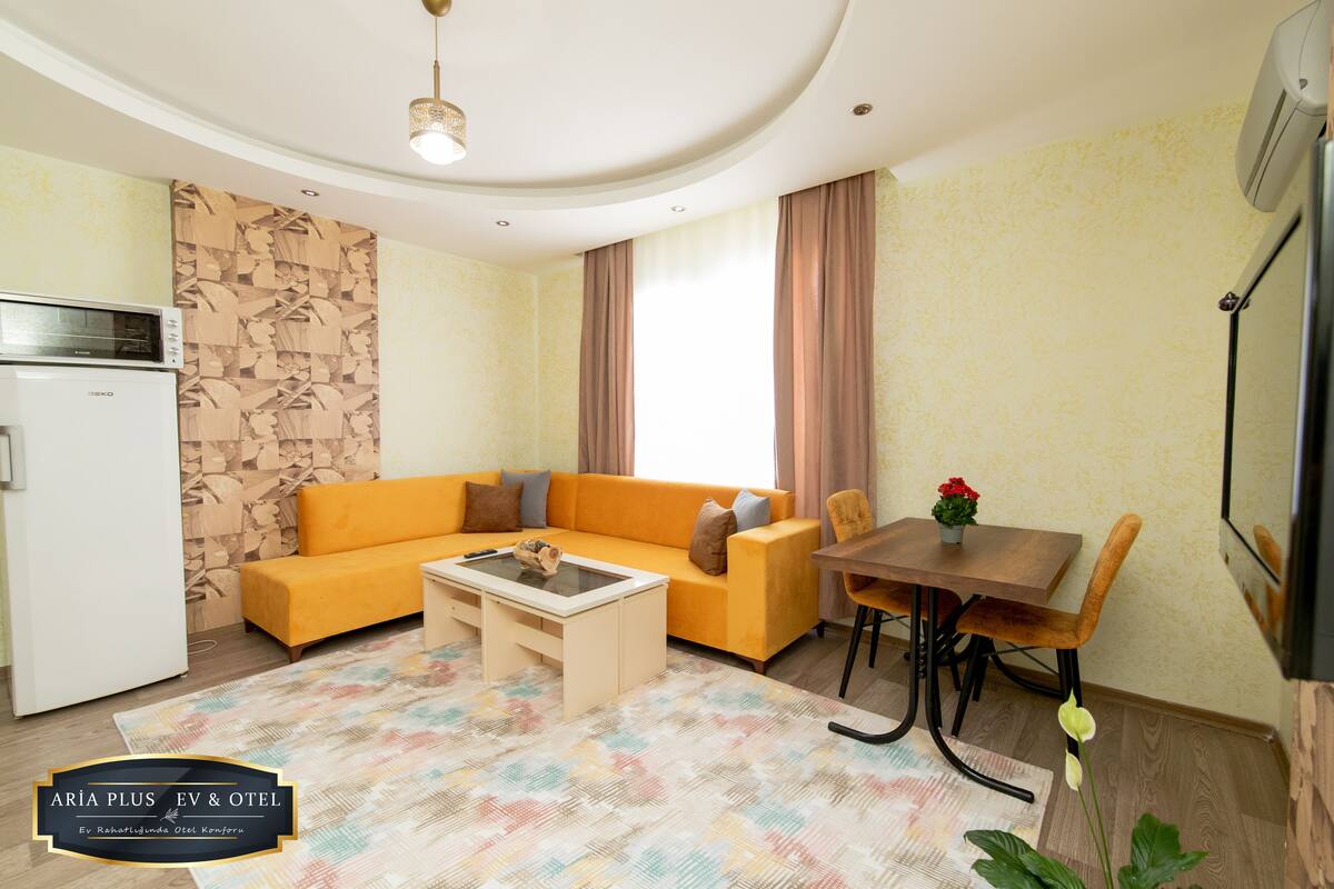 A modern living room with a sofa, coffee table, and dining table.