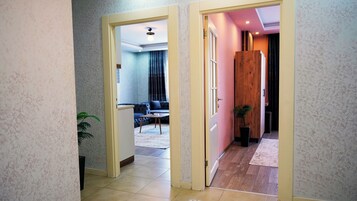 Un pasillo con una decoración moderna que conduce a un área de estar con un sofá y una mesa de centro.
