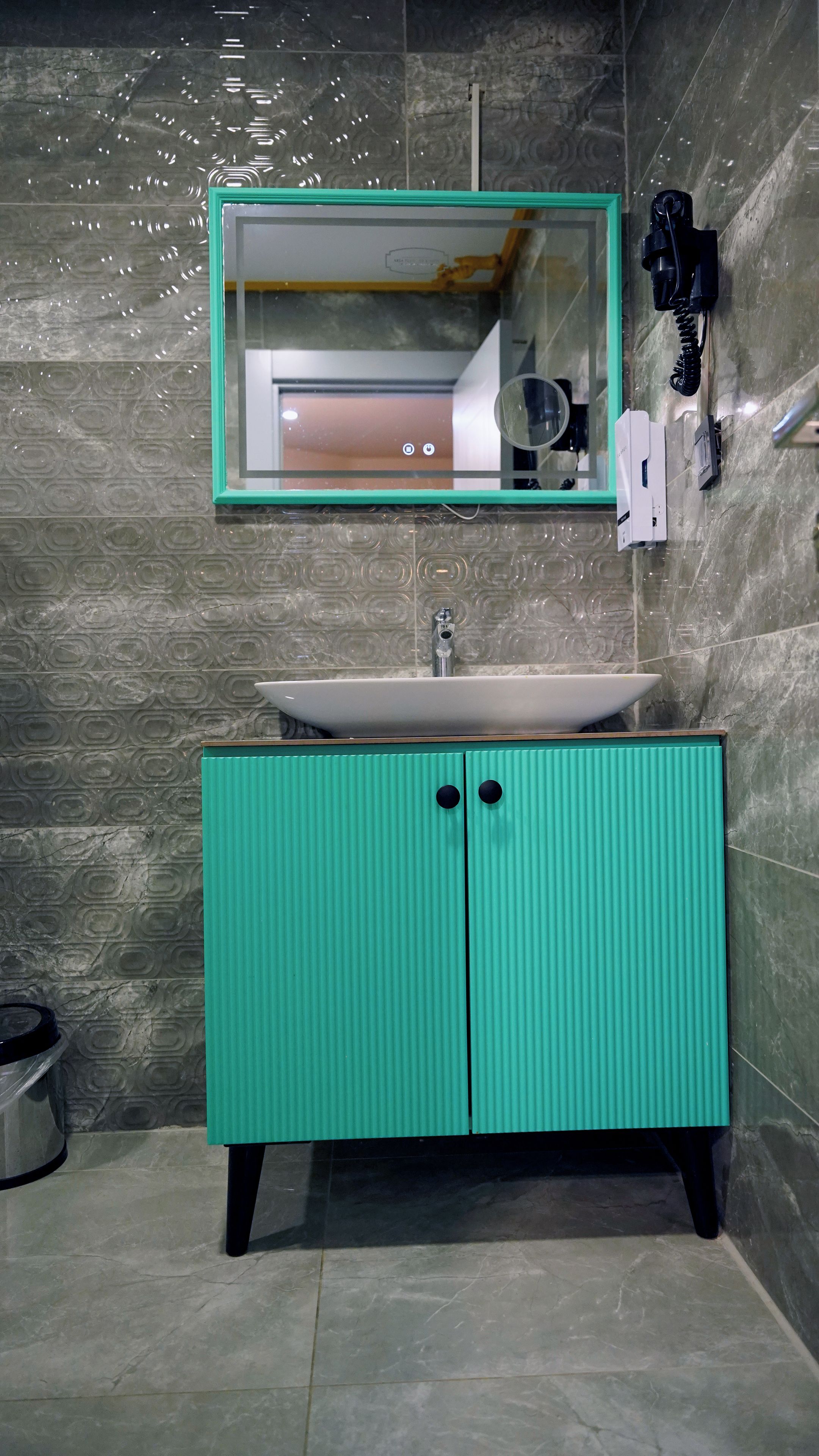 Une salle de bain avec un lavabo, un miroir et un meuble de rangement.