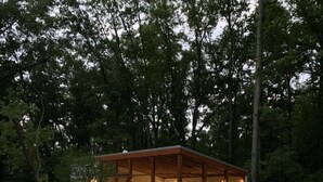Une piscine dotée d’une terrasse en bois, de chaises longues et d’un espace salon abrité.