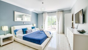 A modern bedroom with a large bed, bedside tables, a dresser, a TV, and a window with curtains. - Central Finca in Mallorca Finca Alegre with pool (Lloseta)