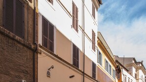 Un carrer empedrat flanquejat per edificis històrics, amb una varietat d'estils arquitectònics i un cel blau clar.