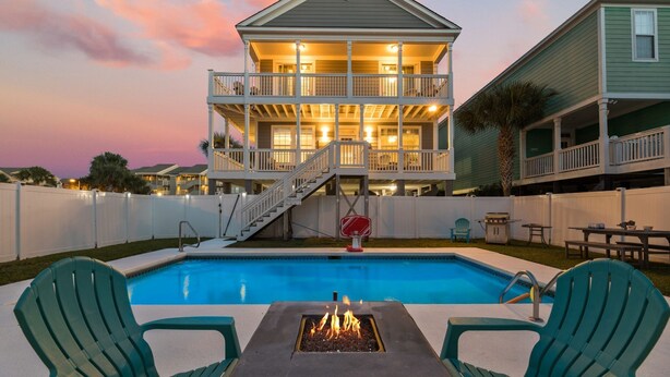A two-story house with a balcony and a swimming pool.