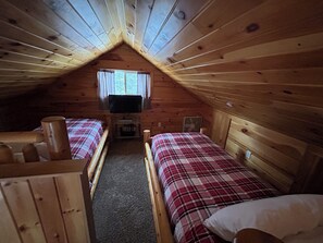 A cabin with two wooden beds, a television, and a window with curtains. - Cozy Cabin in the Beautiful Upper Michigan (Rock)