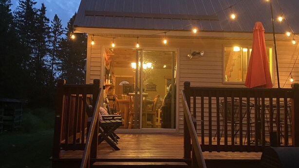A wooden deck with a staircase leading to a covered entrance. - Cozy Cabin in the Beautiful Upper Michigan (Rock)