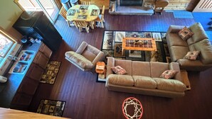 A cabin interior with a dining area, sofa, fireplace, and wooden walls. - Cozy Cabin in the Beautiful Upper Michigan (Rock)
