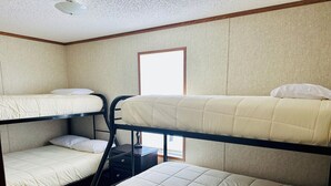 A bunk bed room with a window, a nightstand, and a door. - KINGFISH LODGE - PRIVATE MAINTAINED 3 BEDROOM 2 BATHROOM PRIVATE RENTAL (Buras)