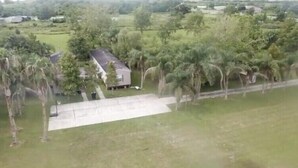 A residential area with a house surrounded by trees and a paved driveway. - KINGFISH LODGE - PRIVATE MAINTAINED 3 BEDROOM 2 BATHROOM PRIVATE RENTAL (Buras)