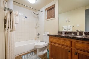 Ein Badezimmer mit Badewanne, Toilette und Waschtisch.