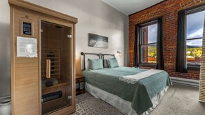 Une chambre à coucher avec un lit, une armoire en bois, une fenêtre donnant sur un beau paysage et un tableau accroché au mur.