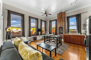 a living area and dining space with hardwood floors and high ceilings