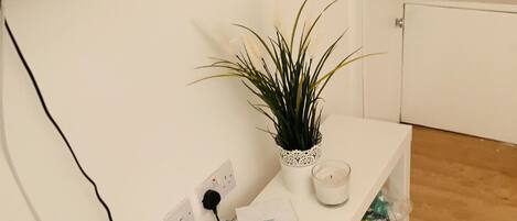 A white bench with a potted plant and a candle.