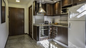 Une cuisine moderne dotée d’appareils électroménagers en acier inoxydable, de meubles en bois et d’un four encastré.