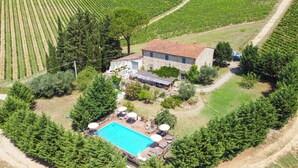 Vue aérienne d’une propriété dotée d’une piscine, d’un espace de détente extérieur et d’un bâtiment en pierre.