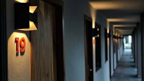 A hotel hallway with illuminated room numbers and doors.