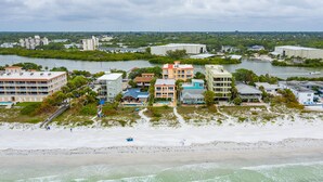 A coastal hotel with multiple buildings, a beach, and a marina.