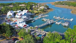 A marina with boats docked, a waterfront restaurant, and a view of the water.