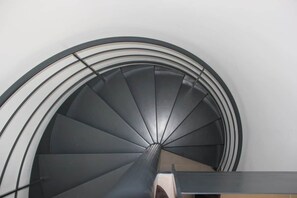 A spiral staircase with a modern design, leading to an upper floor.