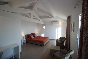 Une chambre à coucher avec un lit, un bureau, une chaise et une fenêtre.