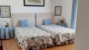 Ein Zimmer mit zwei Betten, einem kleinen Tisch und einem Stuhl.