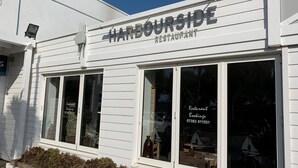 Un edificio bianco con ampie finestre e il cartello "HARBORSIDE RESTAURANT".