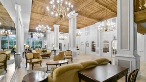 A spacious lobby with high ceilings, chandeliers, and a mix of seating arrangements including sofas and chairs. - Pool/Valet/TropicalOceanView 1brwithTerrace (Palm Beach)