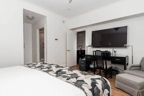 A bedroom with a bed, a desk, a chair, and a television. - Pool/Valet/TropicalOceanView 1brwithTerrace (Palm Beach)