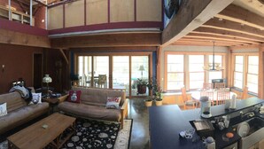A spacious living area with a sofa, dining table, and kitchen area. - Stille Wasser, Quiet, secluded spot on Saco River with Dock (Boat lift option) (Buxton)