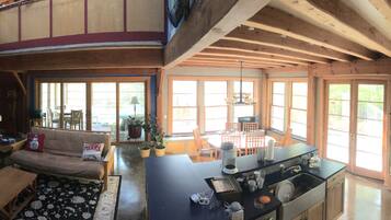 A spacious living area with a sofa, dining table, and kitchen area.