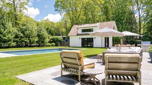 A backyard with a swimming pool, outdoor furniture, and a barbecue grill. - Traditional-style home with pops of patterns and vibrant colors, private... (Sag Harbor)