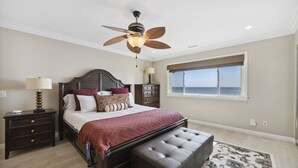 A bedroom with a bed, nightstands, a ceiling fan, a window with a view, and a rug. - BEACH FACING! Large 3BR - 180 panoramic ocean views, steps to sand and Village! (Carlsbad)