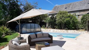 A patio area with a hot tub, wicker furniture, and a swimming pool. - Fully renovated cottage with swimming pool in the heart of Cotentin (MONTEBOURG)