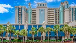 A large hotel with multiple floors, a prominent clock tower, and a parking garage. - BEAUTIFUL PRIVATE 9TH FLOOR OCEAN VIEW CONDO; NEWLY RENOVATED OCEANFRONT RESORT (Myrtle Beach)