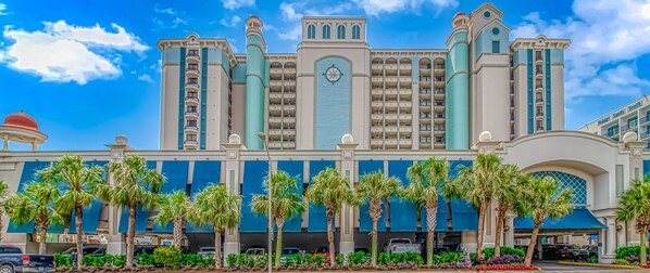 A large hotel with multiple floors, a prominent clock tower, and a parking garage.