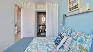 Ein Schlafzimmer mit einem Bett, einem Regal mit Kerzen und einem Poster an der Wand.