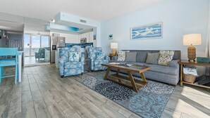 A modern living room with a sofa, coffee table, and patterned rugs. - Best view on the Gulf! Heated pool and beach gear included! Book today!  (Navarre)