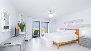 Une chambre moderne avec un grand lit, un bureau, une chaise et un balcon avec vue.