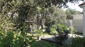 A garden with a pergola, potted plants, and a wooden fence. - Villa Tanchet-Plage Sea view (Les Sables-d'Olonne)