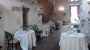 A rustic dining area with stone walls, arched ceilings, and round tables set for dining. - Junior Suite Deluxe - Hotel Lady Lusya ★★★★ (Sicilia)