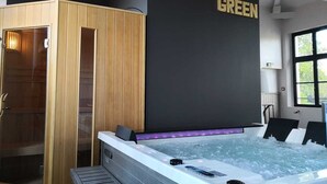Un spa moderno con sauna de madera, una bañera grande con hidromasaje y un cartel que dice "COTE GREEN".