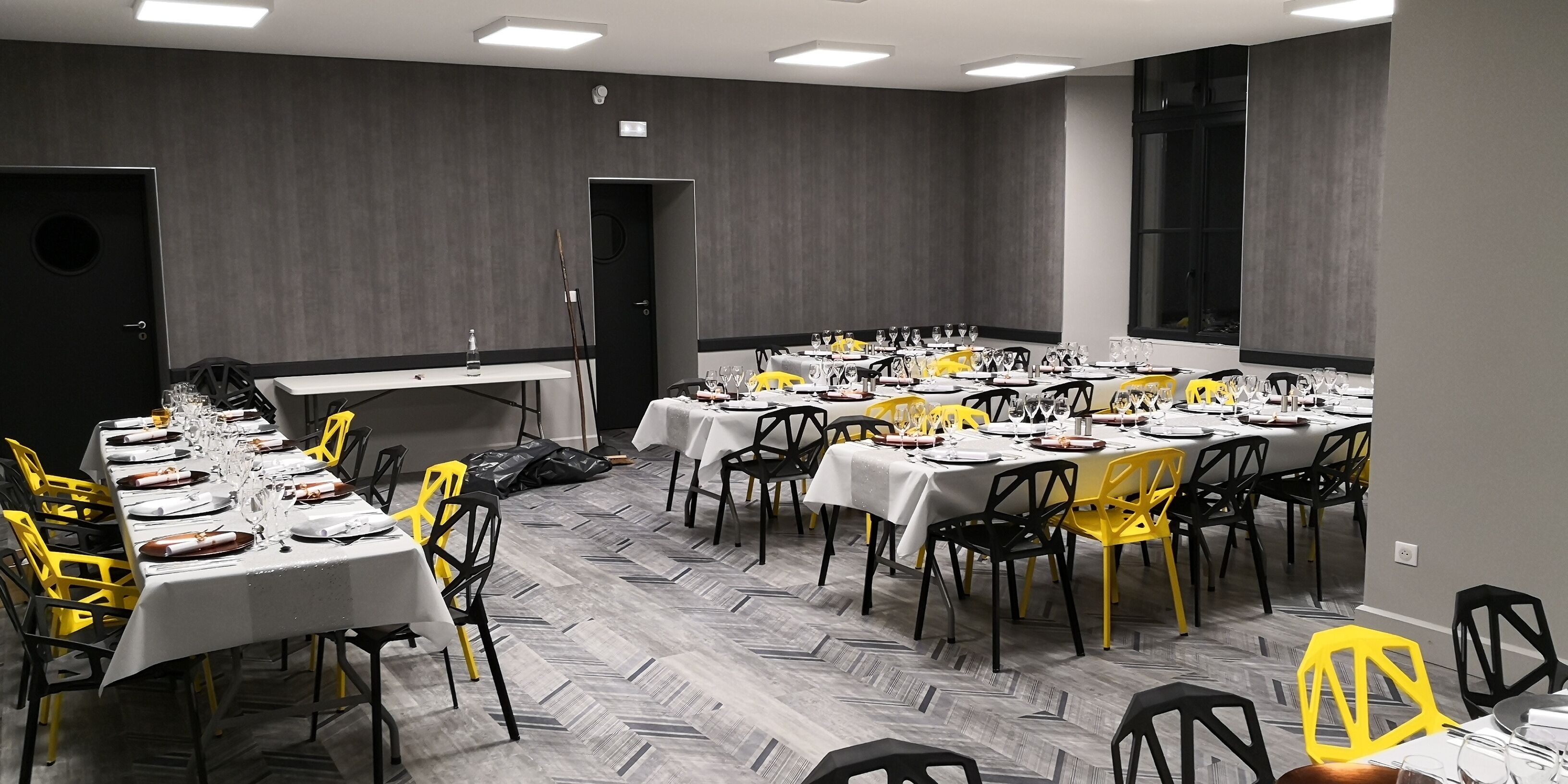 A conference room with multiple tables set for dining, equipped with chairs and table settings.