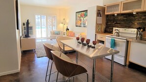Een moderne keuken met een eethoek, een fornuis en een groot raam.