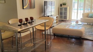 Un salon moderne comprenant un coin repas, un téléviseur et un meuble.