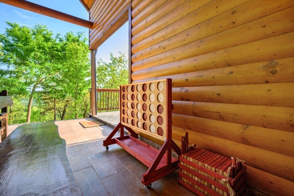 A wooden cabin with a wooden deck and a wooden bench.