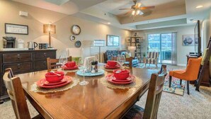 A dining area with a wooden table set for four, surrounded by chairs. There is a ceiling fan above and a kitchen area in the background. - Shifting Gears to Comfort -2BR/2BA @BMS, Elevator (Bristol)