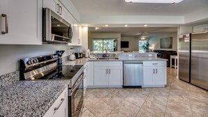 A modern kitchen with granite countertops, stainless steel appliances, and a large island. - Newly Renovated! Prime Location! Premium bedding! Heated Pool! 3 Br/ 2 Bath (Cape Coral)
