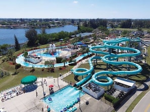 A water park with multiple slides and a swimming pool.